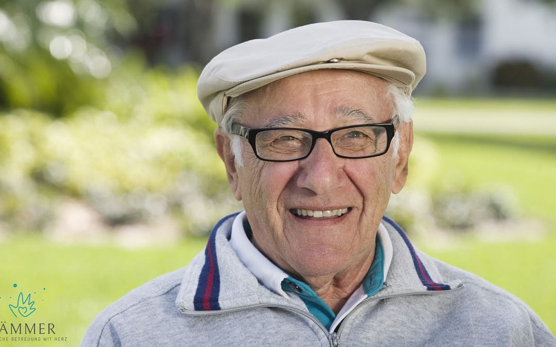 Laechender Senior mit Brille und Mütze