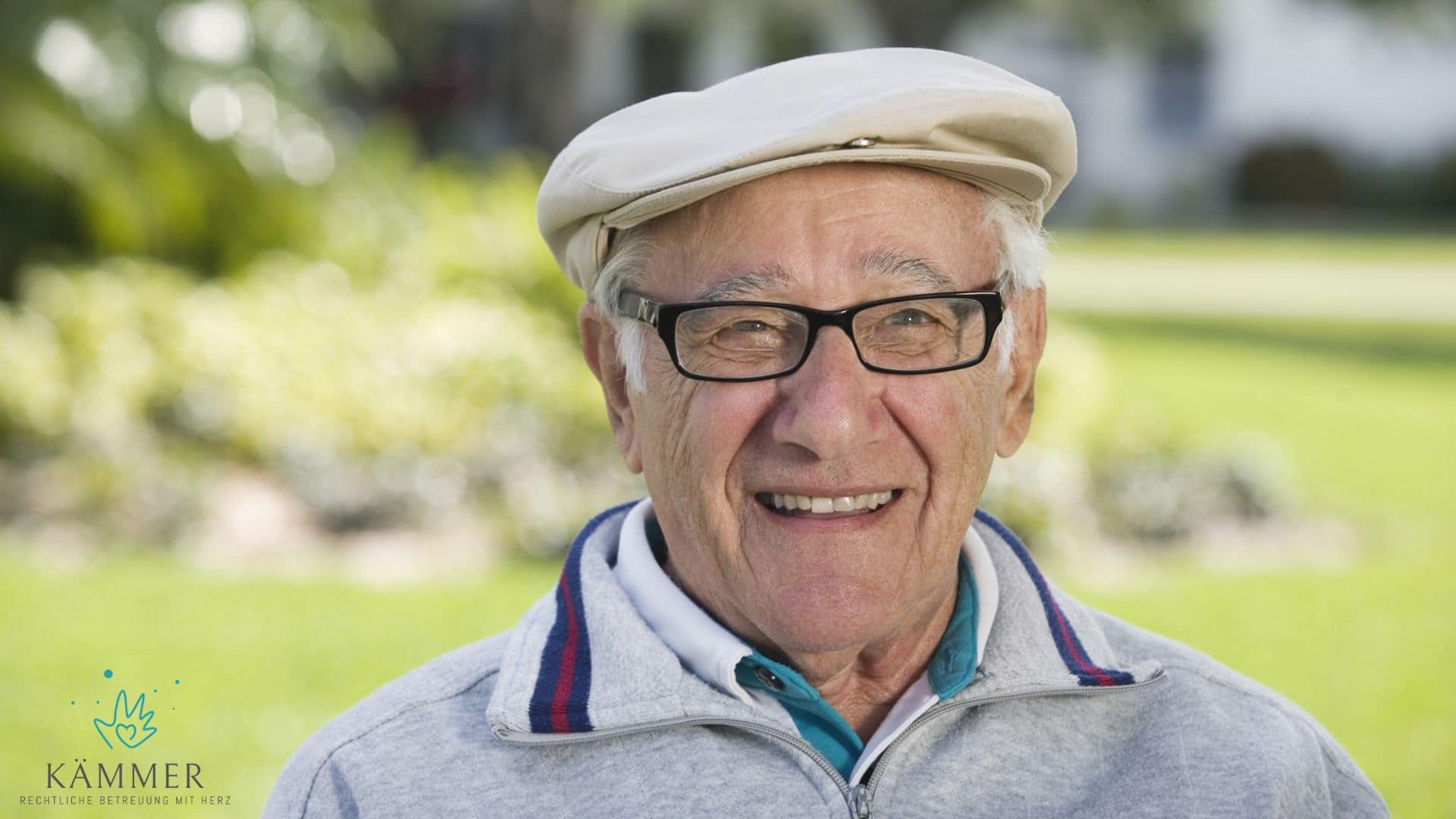 Laechender Senior mit Brille und Mütze